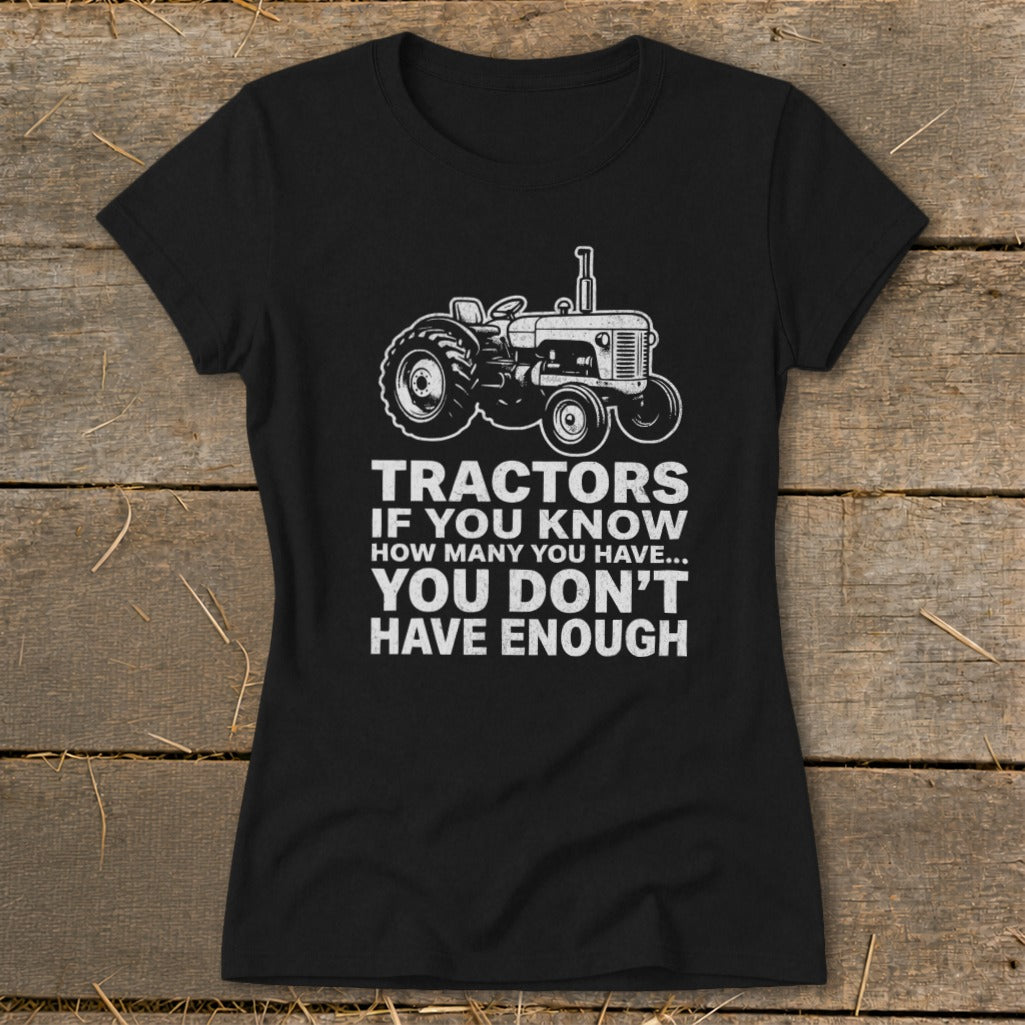 Black t-shirt with a tractor graphic and text "Tractors if you know how many you have... you don't have enough."
