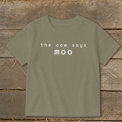 T-shirt with "the cow says moo" text in white on a light olive green background.