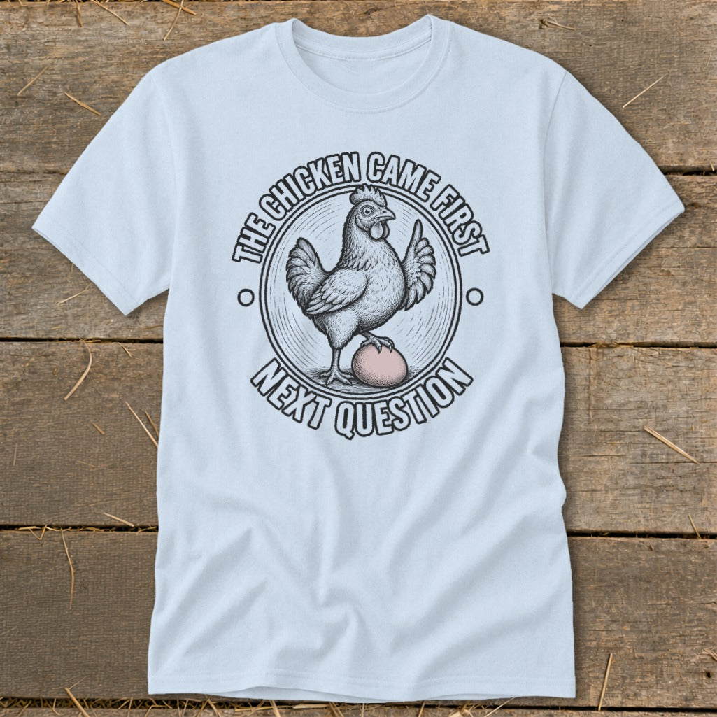 Light blue t-shirt with a chicken and egg graphic and text: "The Chicken Came First, Next Question".