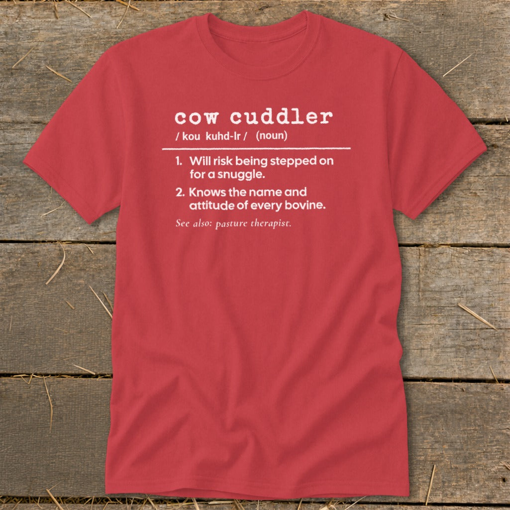 Red t-shirt with "cow cuddler" definition: Will risk being stepped on for a snuggle.
