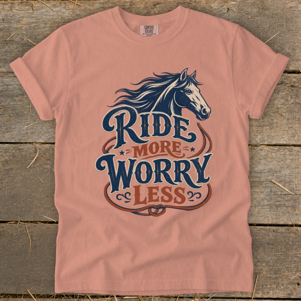 Peach t-shirt with navy blue horse graphic and text "Ride More Worry Less".