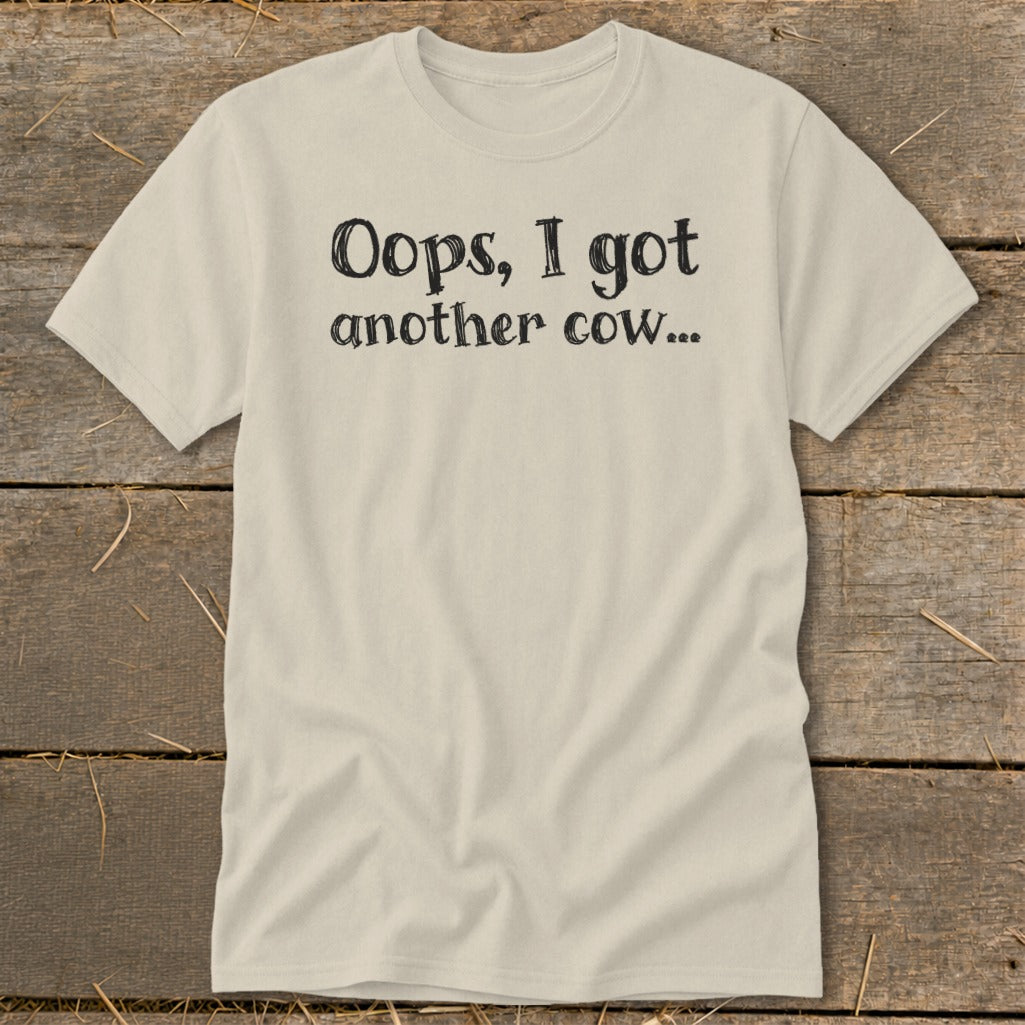 Cream t-shirt with black text reading "Oops, I got another cow..."