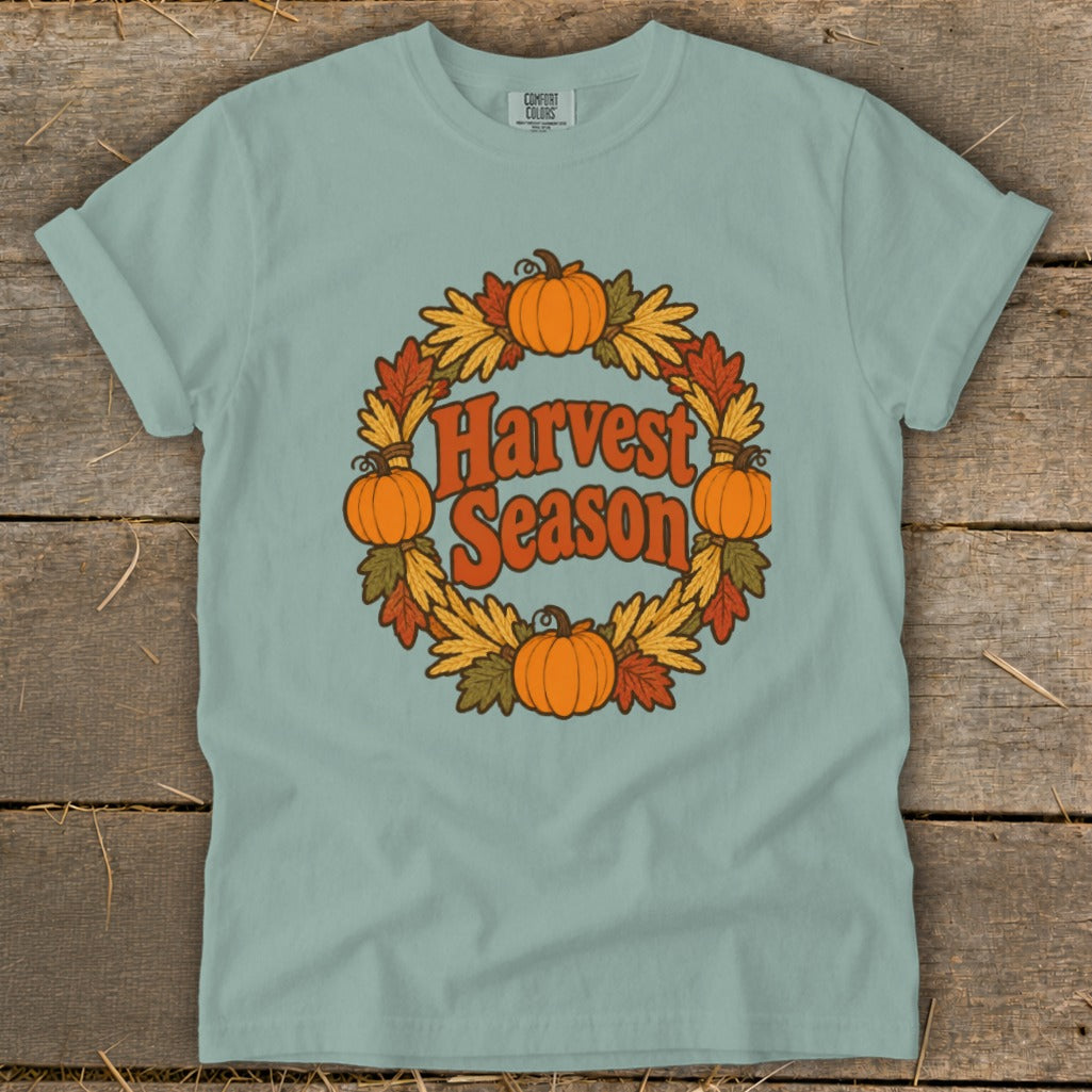 Light blue t-shirt with "Harvest Season" in a wreath of pumpkins and fall leaves.