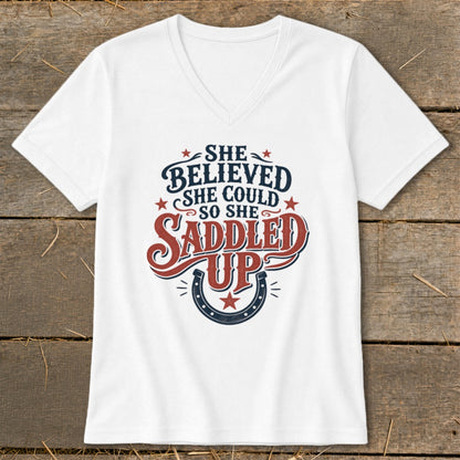 White t-shirt with "She Believed She Could So She Saddled Up" text and horseshoe.