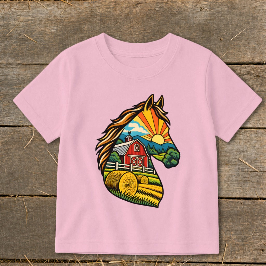 A light pink children's t-shirt features a colorful graphic of a horse head filled with a farm scene.