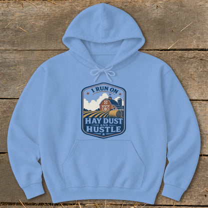 Light blue hoodie with a crest graphic saying "I Run On Hay Dust And Hustle"