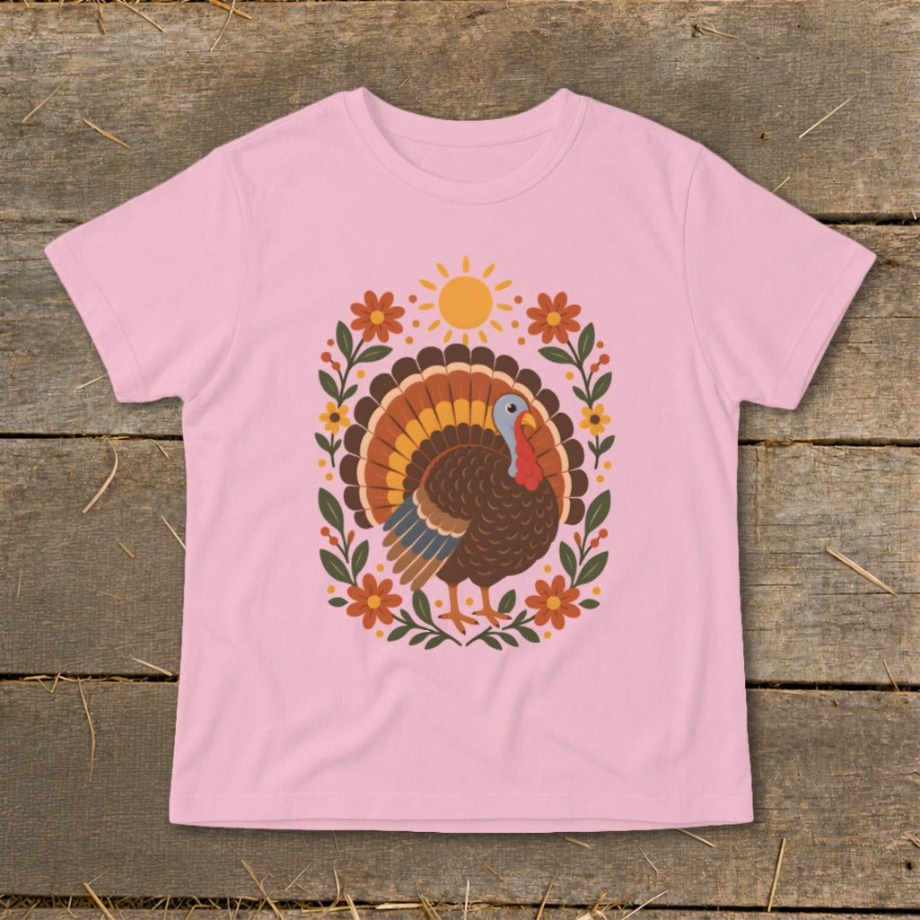 Pink t-shirt with a colorful turkey and floral design, featuring a sun.