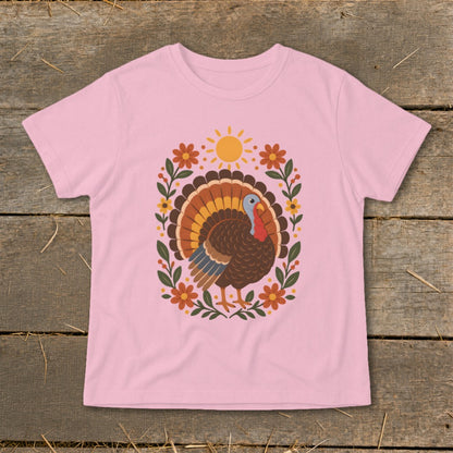 Pink t-shirt with a colorful turkey and floral design, featuring a sun.