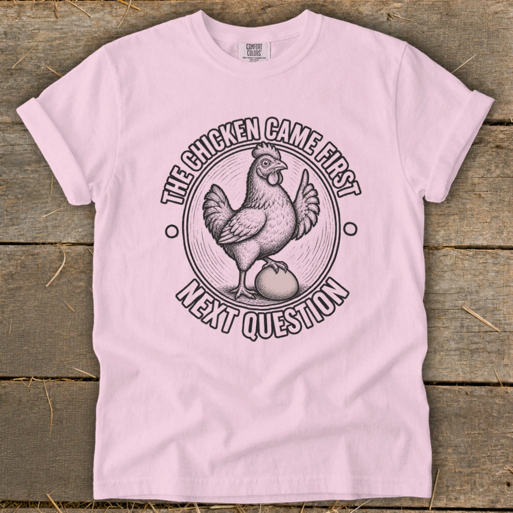 Pink t-shirt with chicken and egg graphic, reading "The chicken came first. Next question."