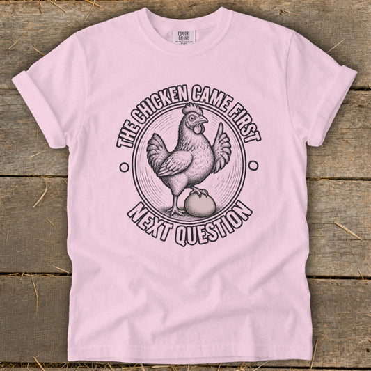 Pink t-shirt with chicken and egg graphic, reading "The chicken came first. Next question."