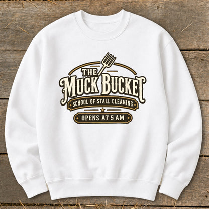 White sweatshirt with "The Muck Bucket School of Stall Cleaning Opens at 5 AM" graphic.