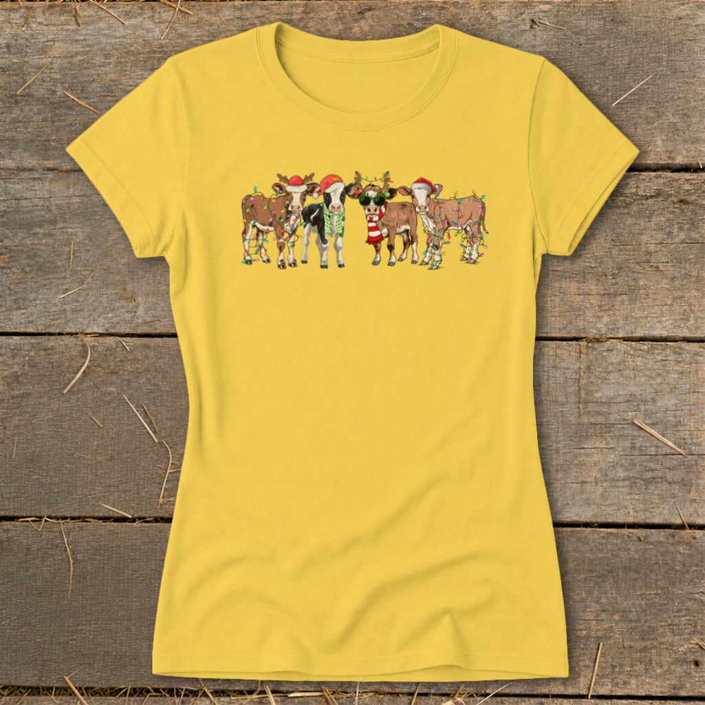 Cartoon cows wearing Santa hats and Christmas lights on a yellow t-shirt.