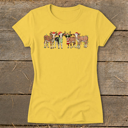 Cartoon cows wearing Santa hats and Christmas lights on a yellow t-shirt.