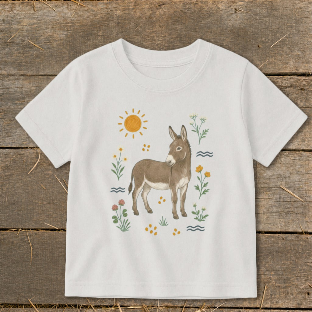White t-shirt with watercolor illustration of a donkey among flowers and sun.