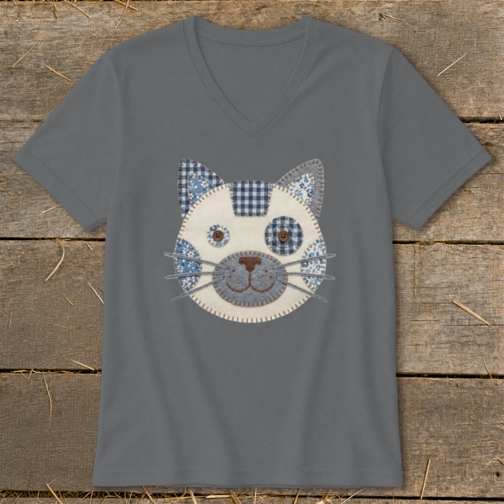 Grey v-neck t-shirt with a stitched cat face appliqué made of blue and white patterned fabric.