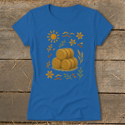 Blue t-shirt with a central graphic of three hay bales surrounded by a sun, flowers, and leaves.