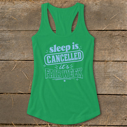 Green tank top with "sleep is CANCELLED it's FAIR WEEK" text in light blue.