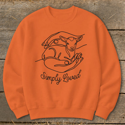 Orange crewneck sweatshirt with line art of hands holding a lamb and the text "Simply Loved".