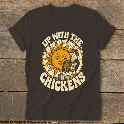 Dark brown t-shirt featuring a retro graphic of a crowing rooster, sun, and text reading Up With The Chickens.