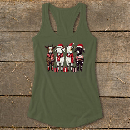 Four goats wearing Santa hats, scarves, and sweaters stand with Christmas gifts.