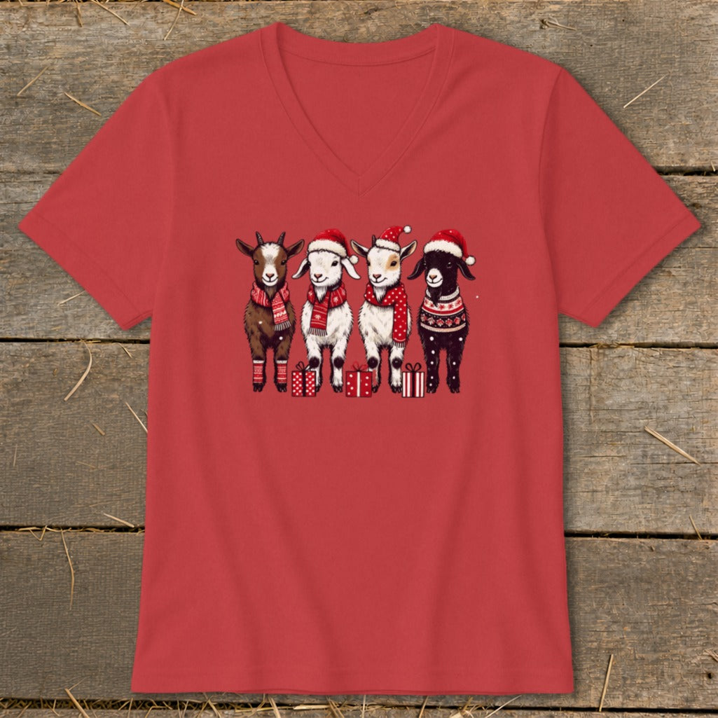 Four festive goats wearing Santa hats and scarves stand with presents.