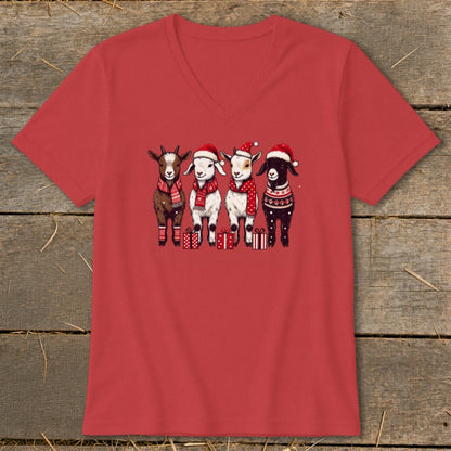 Four festive goats wearing Santa hats and scarves stand with presents.