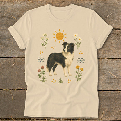 Cream t-shirt with illustration of a border collie surrounded by flowers, sun, and waves.