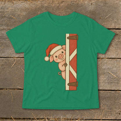 Green t-shirt with a Christmas pig peeking from behind a wooden gate illustration.
