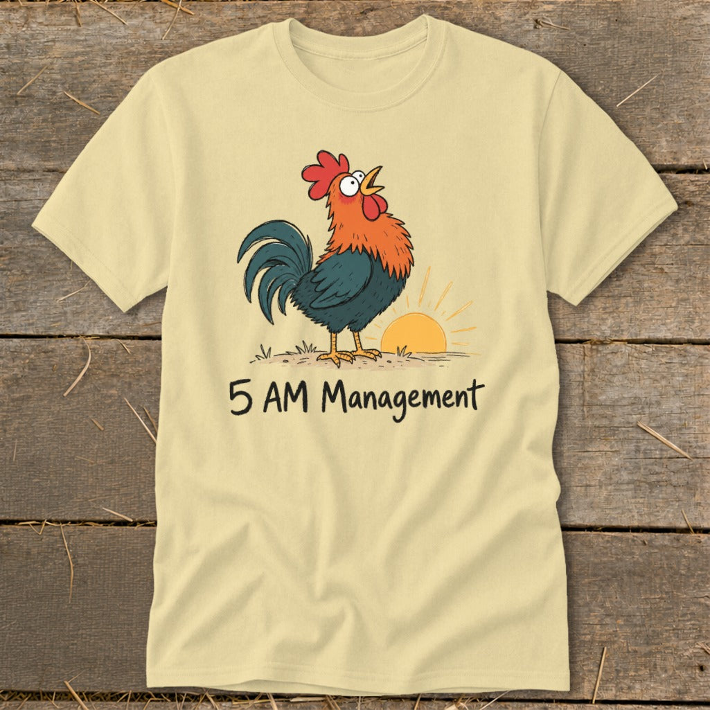 Light yellow t-shirt with a cartoon rooster crowing at sunrise and the text "5 AM Management".
