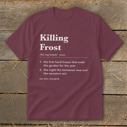 A maroon crewneck t-shirt featuring dictionary-style text defining Killing Frost displayed against a rustic wooden background.