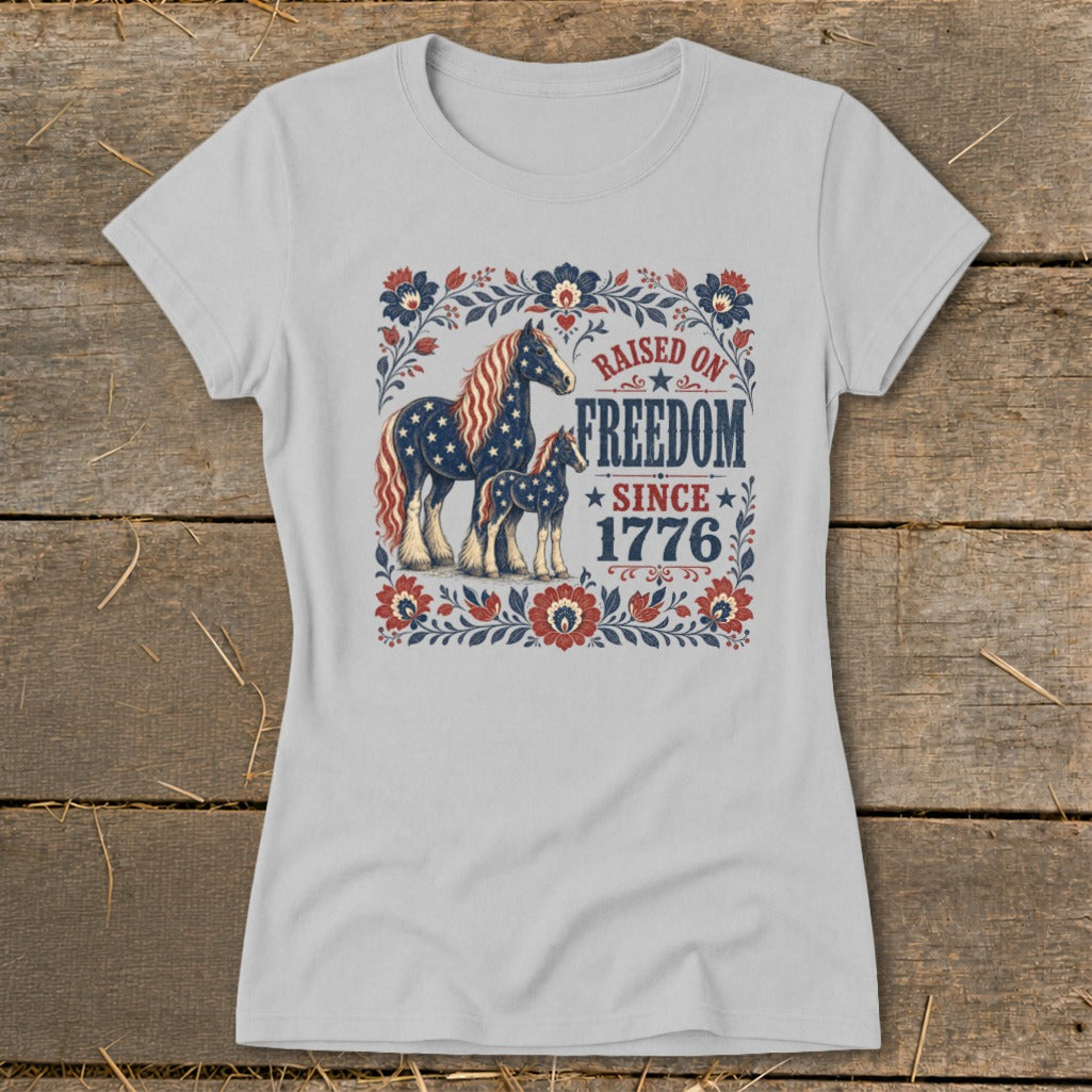 T-shirt with horses and "Raised on Freedom Since 1776" text in patriotic colors.