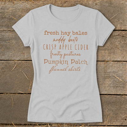 Light grey t-shirt with text listing fall activities like hay bales, cider, and flannel shirts.