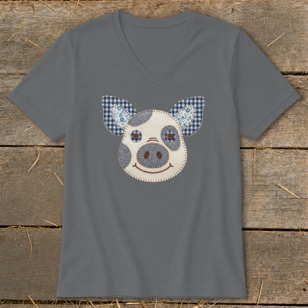 Gray t-shirt with a fabric applique of a pig's face with blue gingham ears.