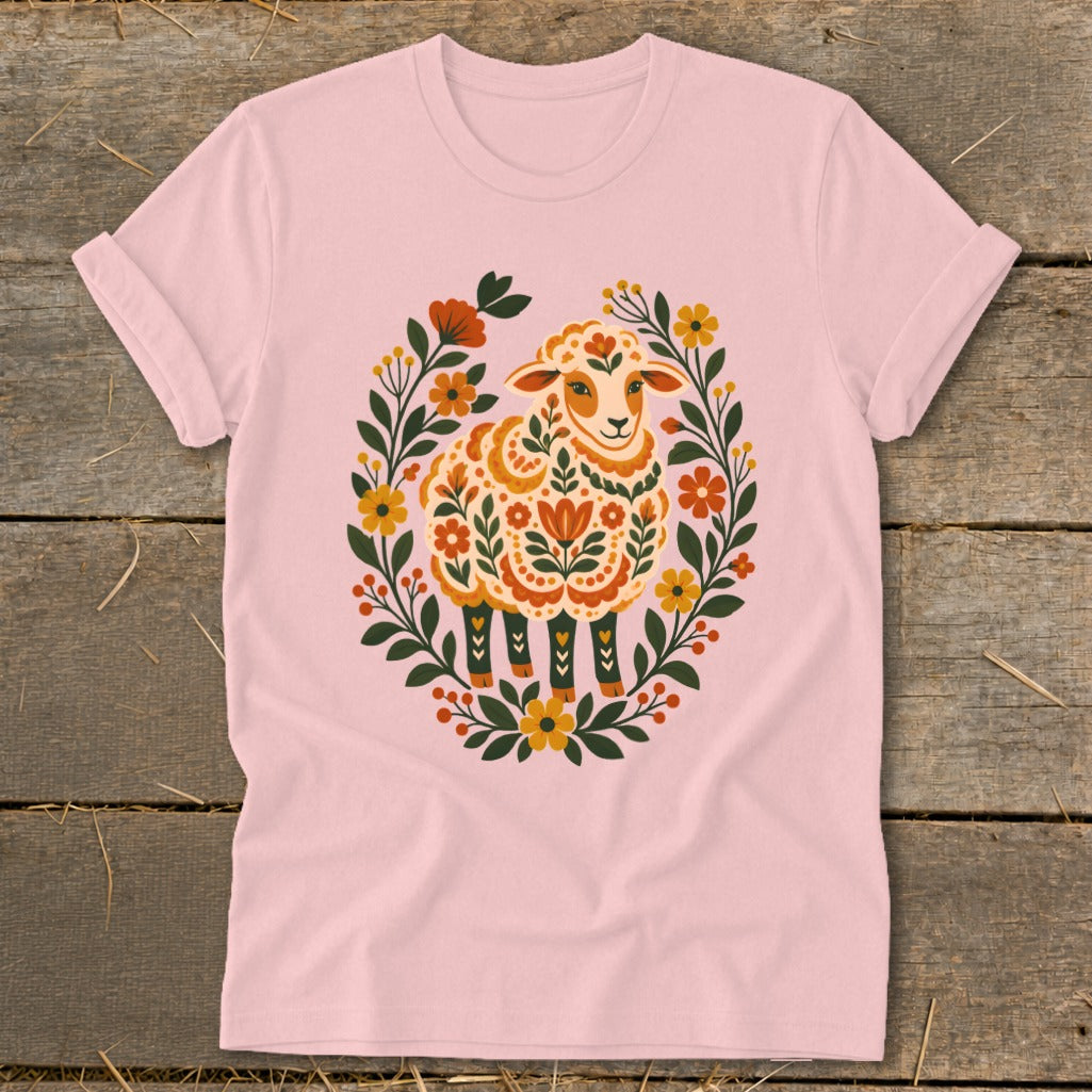 Pink t-shirt with folk art sheep design surrounded by floral wreath.