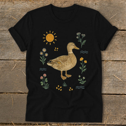 Black t-shirt with a duck illustration surrounded by flowers, sun, and water.