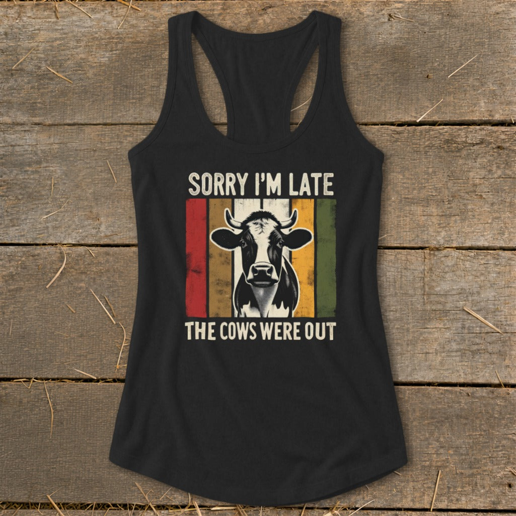 Black tank top with a cow graphic and text "SORRY I'M LATE THE COWS WERE OUT".