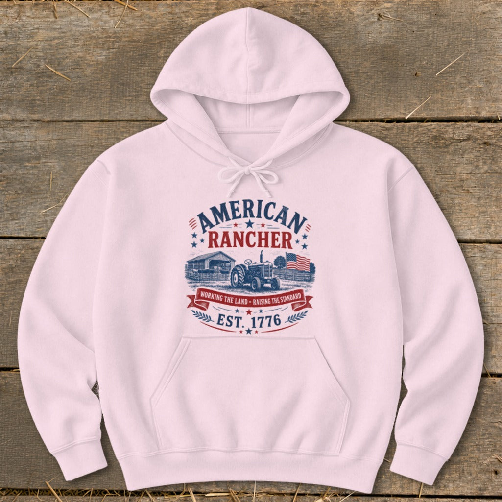 Pink hoodie with "American Rancher" graphic featuring a tractor, barn, and American flag.