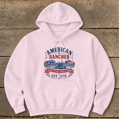 Pink hoodie with "American Rancher" graphic featuring a tractor, barn, and American flag.