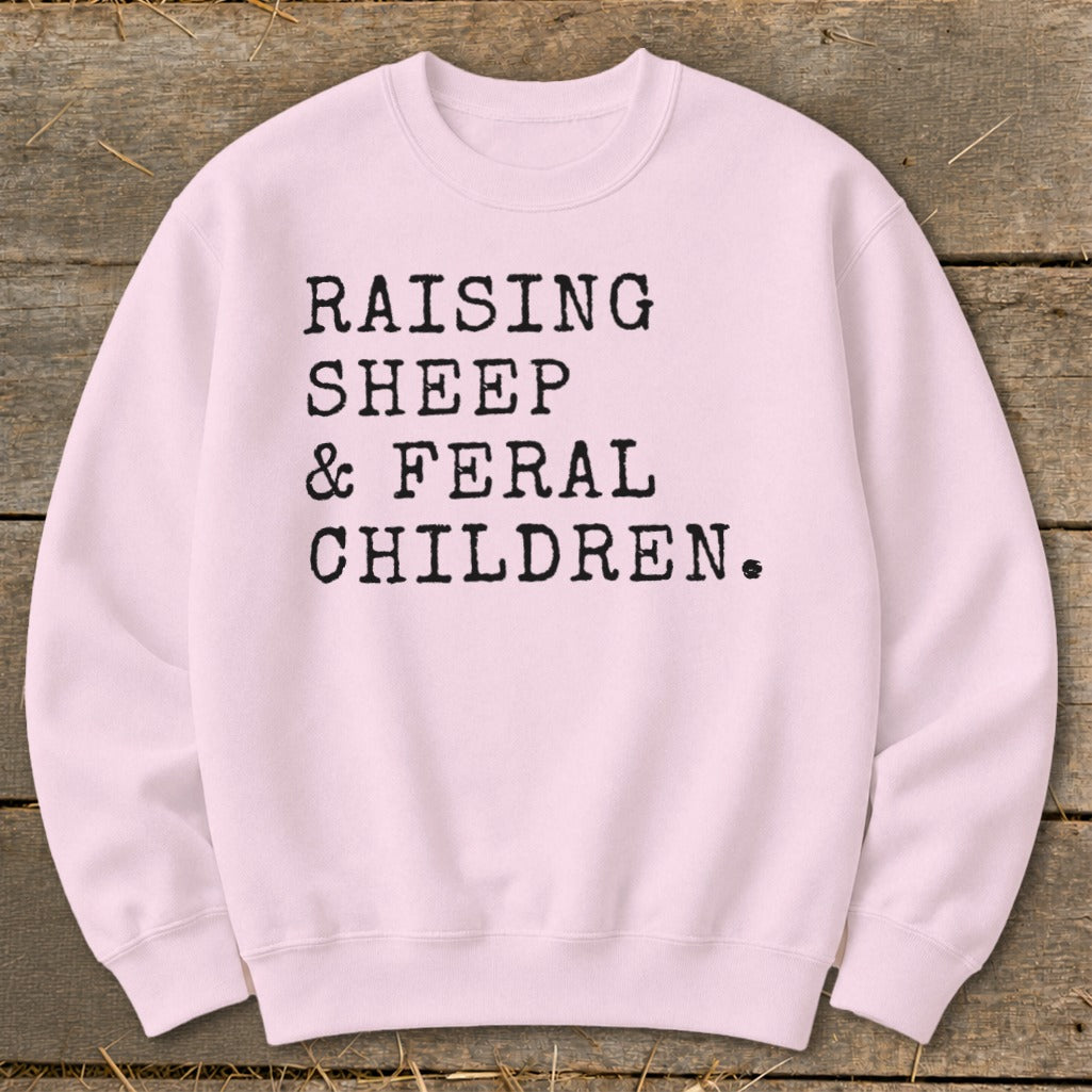 Light pink crewneck sweatshirt with "Raising Sheep & Feral Children" text.