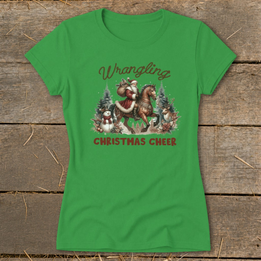 Green t-shirt with Santa riding a horse, text "Wrangling Christmas Cheer", snowman, and deer.