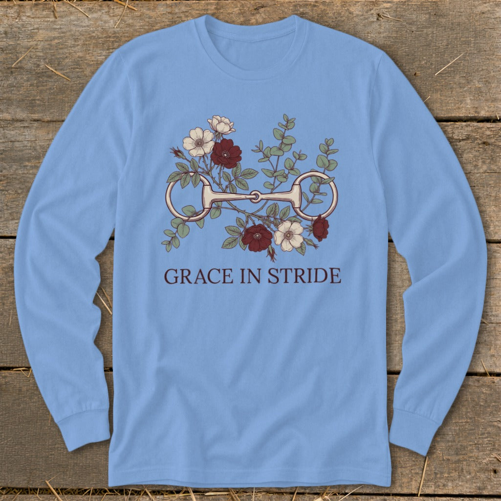 Light blue long-sleeve shirt with horse bit and floral graphic, text "GRACE IN STRIDE".