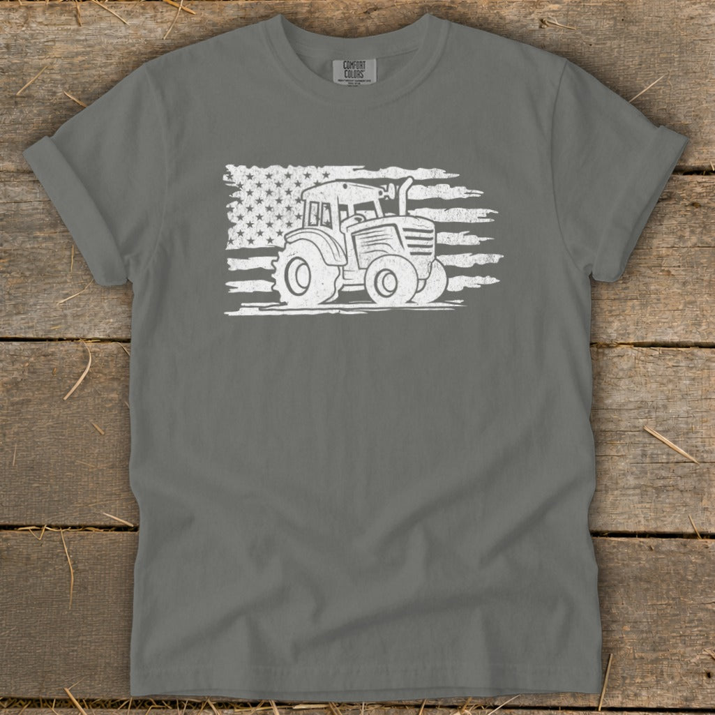Tractor graphic with distressed American flag on gray t-shirt.