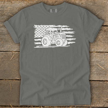 Tractor graphic with distressed American flag on gray t-shirt.