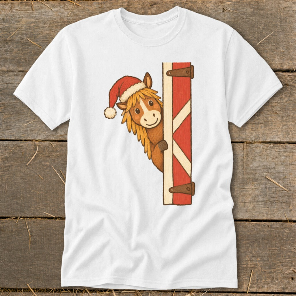 White t-shirt with a cartoon horse wearing a Santa hat peeking from a red barn door.