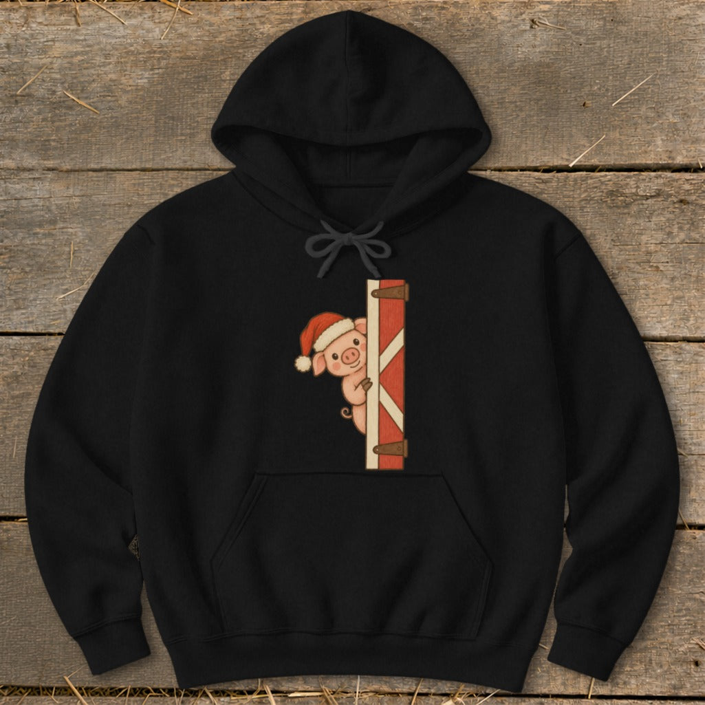 Black hoodie with a cartoon pig wearing a Santa hat peeking from behind a barn door.