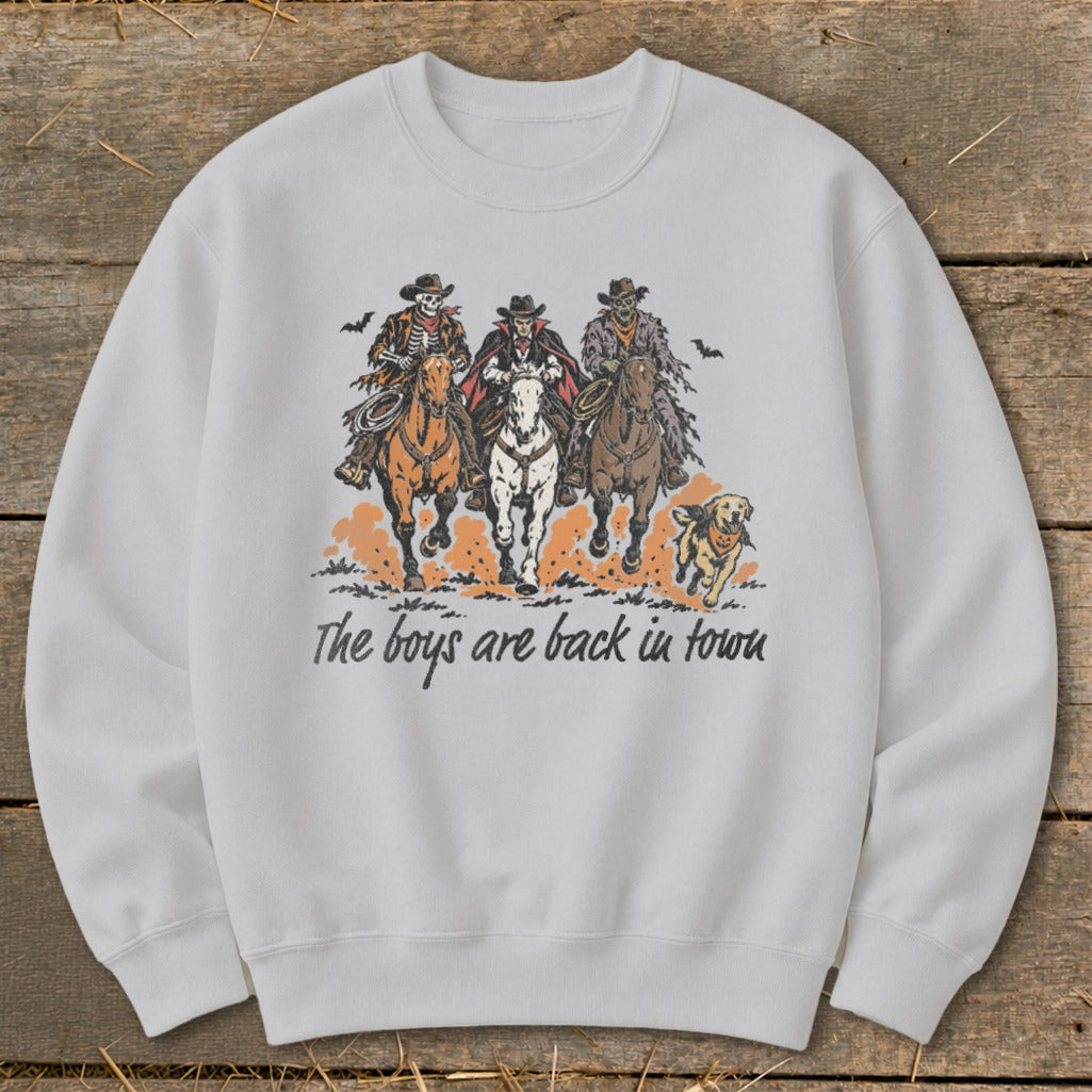 Three skeleton cowboys ride horses with text "The boys are back in town."