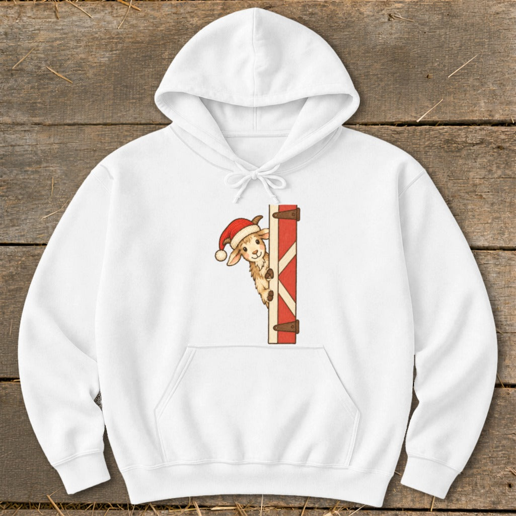 White hoodie with a cartoon lamb wearing a Santa hat peeking from behind a red barn door.