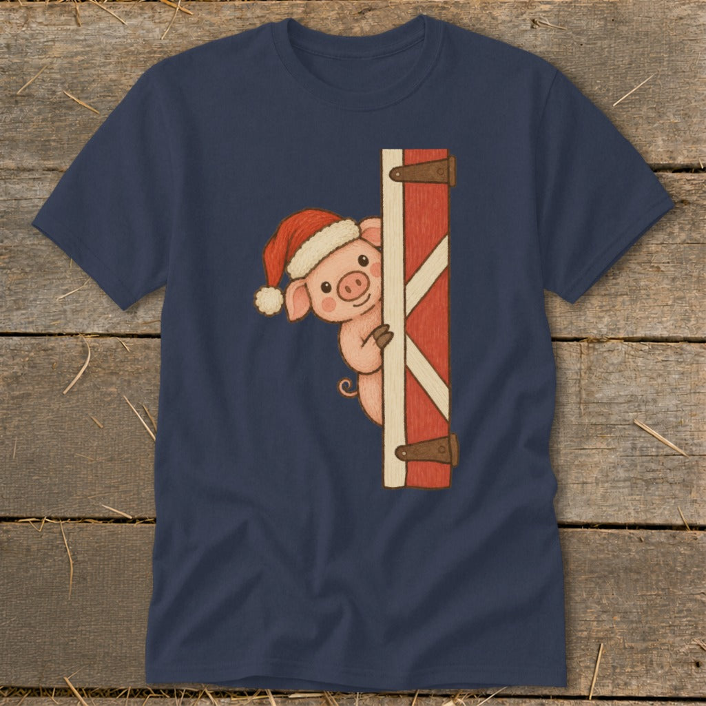 Navy t-shirt with a cartoon pig wearing a Santa hat peeking behind a red barn door.