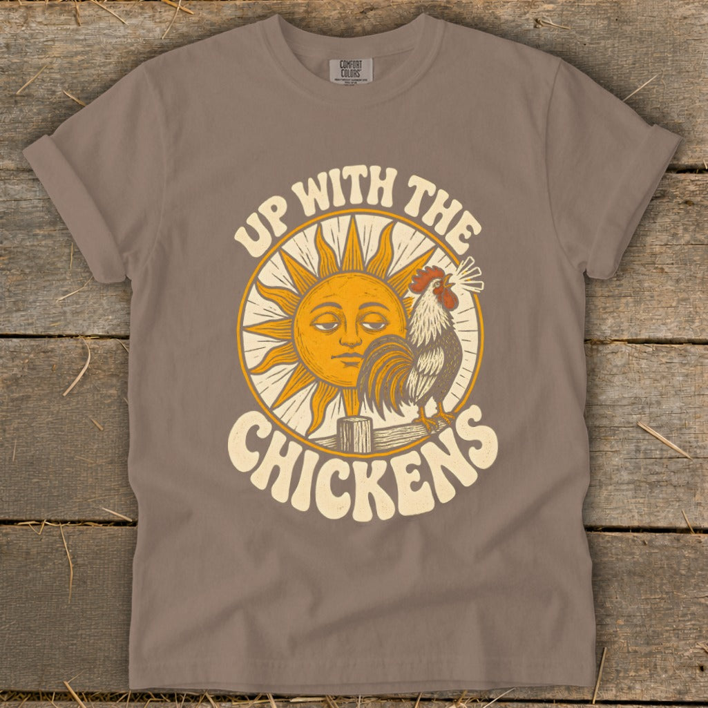 Brown t-shirt featuring a sun graphic, a crowing rooster, and the text Up With The Chickens.