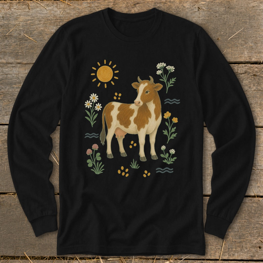Black long-sleeve shirt with a brown and white cow surrounded by flowers and sun.